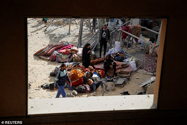 فلسطينيون يجلسون مع ممتلكاتهم في موقع غارة إسرائيلية على منزل، وسط الصراع المستمر بين إسرائيل وحماس
