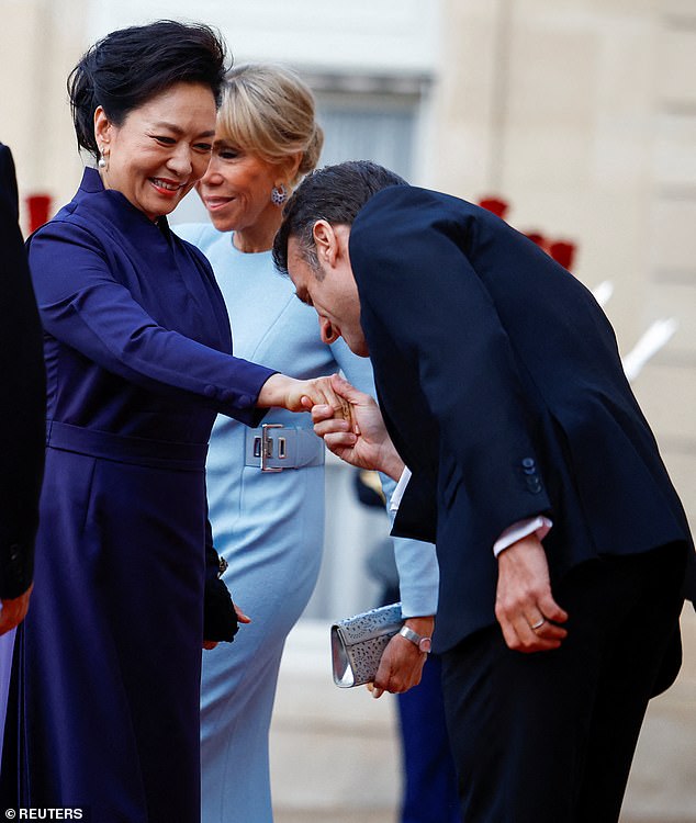 تم تصوير الرئيس ماكرون (في الصورة، على اليمين) وهو يقبل يد بينغ ليوان (في الصورة، على اليسار) أثناء ترحيبها بها في قصر الإليزيه