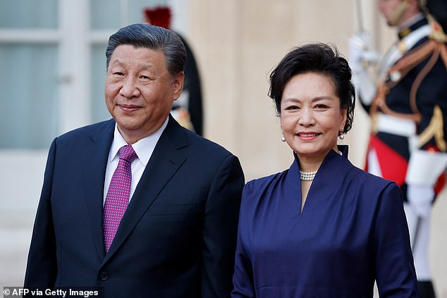 الرئيس الصيني شي جين بينغ (في الصورة، يسار) وزوجته بنغ لي يوان (في الصورة، يمين) يقفان عند وصولهما لتناول العشاء الرسمي