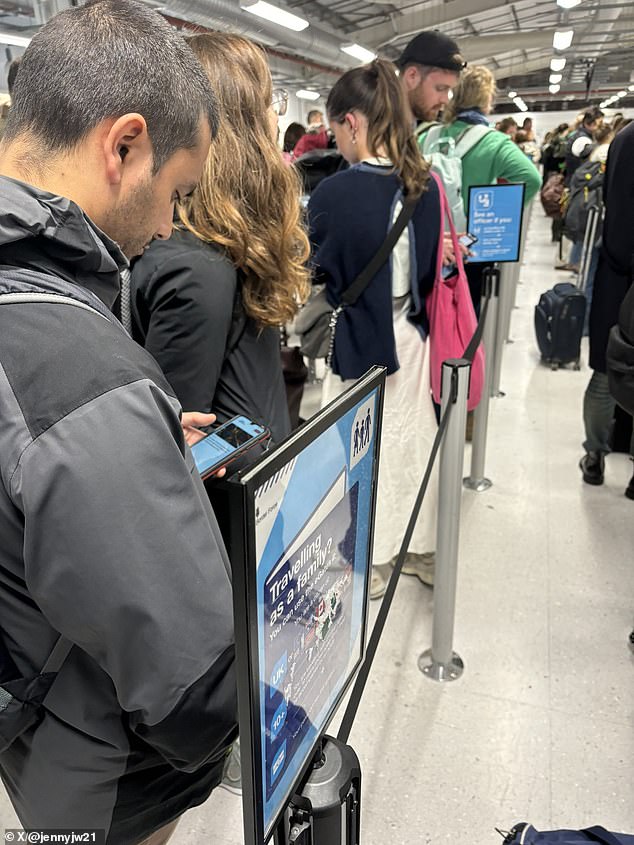 يتحقق الأشخاص في مطار إدنبره من التحديثات على هواتفهم أثناء انتظار معالجتها