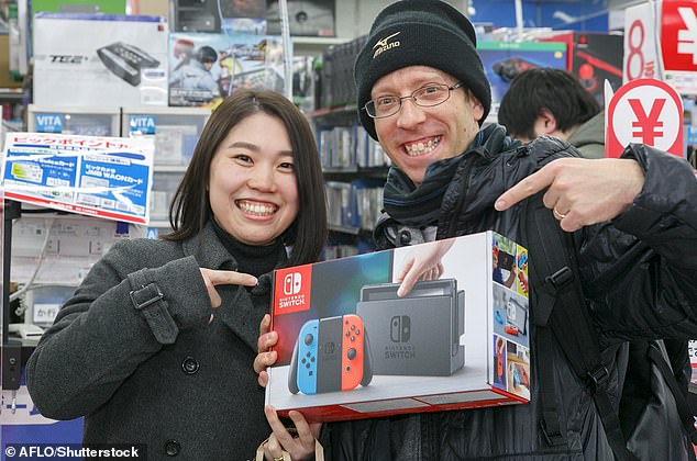 يعرض المشجعون وحدة التحكم Nintendo Switch الجديدة الخاصة بهم في متجر بيع الإلكترونيات الاستهلاكية بالتجزئة Bic Camera في طوكيو، اليابان، 3 مارس 2017