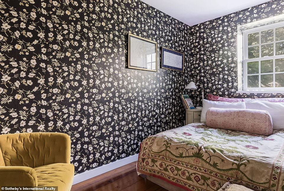 تتميز غرفة النوم الأخرى بورق حائط ملفت للنظر مع طباعة الأزهار على خلفية حقل أسود، وتتماشى بشكل أنيق مع الأرضيات الصلبة البنية